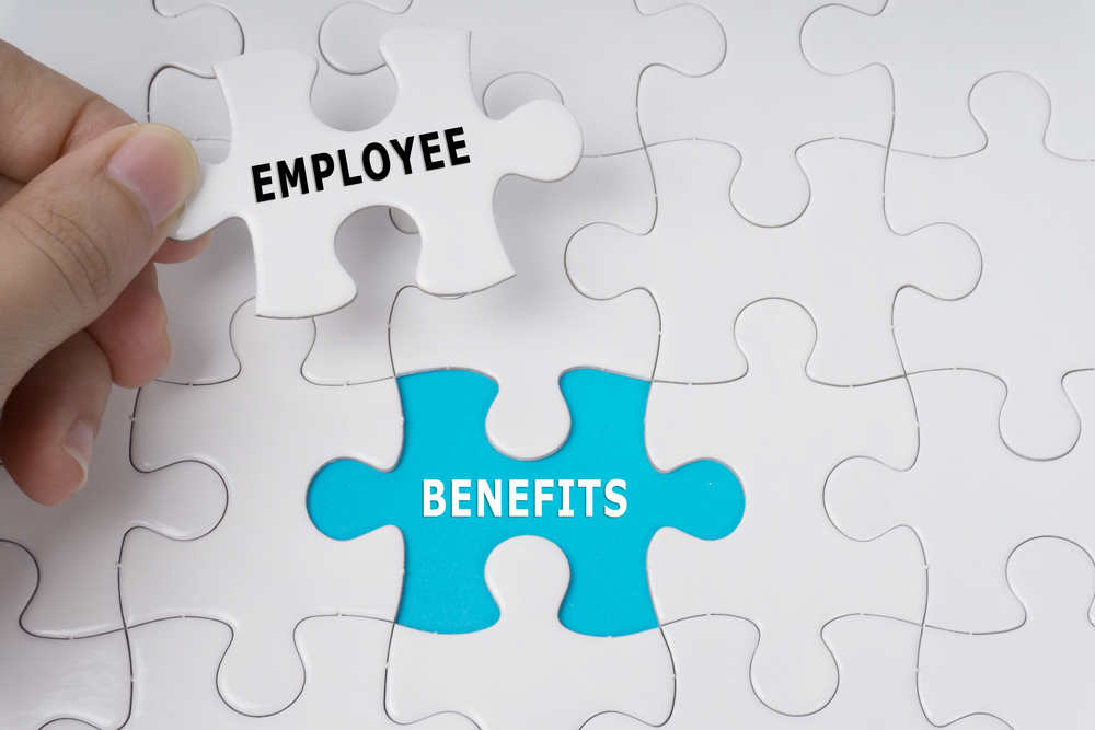Hand,Holding,Piece,Of,Jigsaw,Puzzle,With,Words,Employee,Benefits. employee benefits