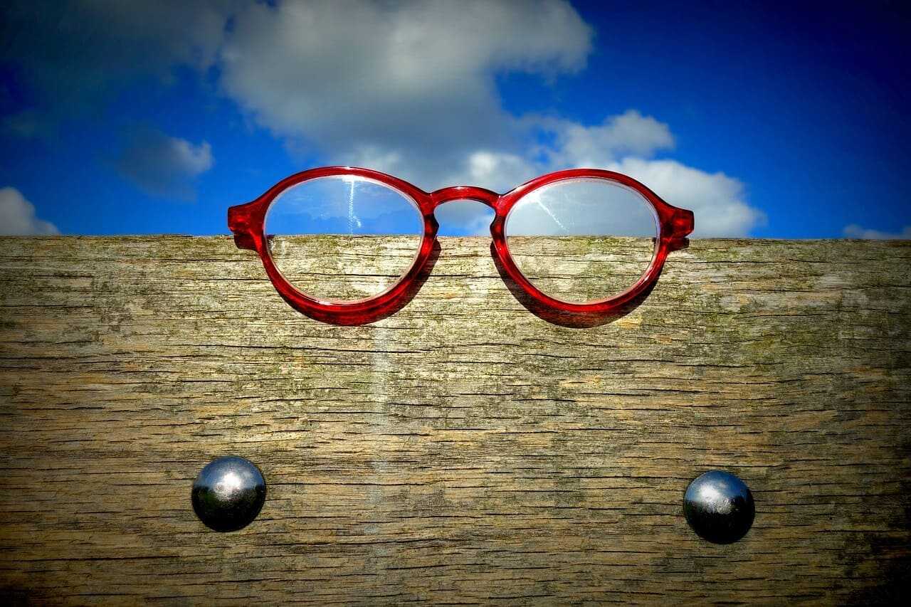 1OK.VISION_Vision_Insurance_Tends-ezgif.com-webp-to-jpg-converter red framed glasses on the fence