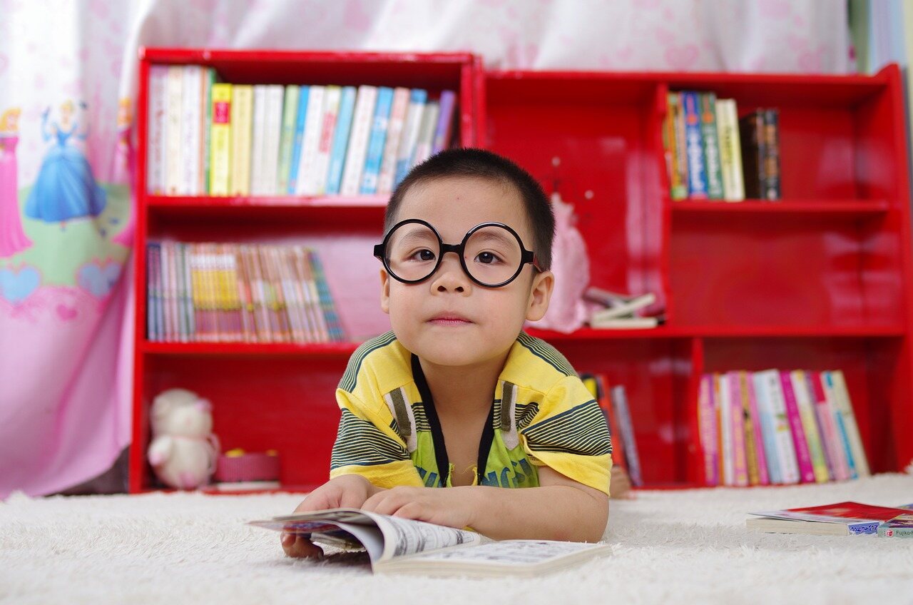 1Vision_Direct_Of_Oklahoma_Children_Eye_Health boy in the glasses reads the book