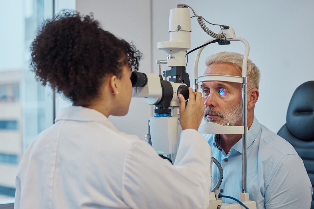 Vision brokers conducts an eye examination on a mature male patient using an advanced optical device.