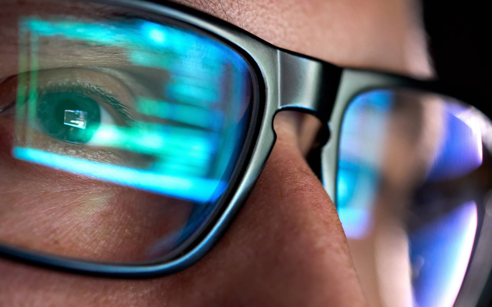 ok.vision-vision-plans-scaled A close-up of a person’s glasses reflecting digital graphics, symbolizing focus and strategy related to vision plans.