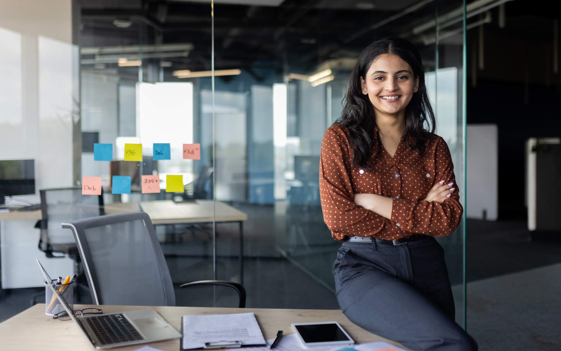 Confident young professional in a modern office setting, representing the impact of modern employee benefits.