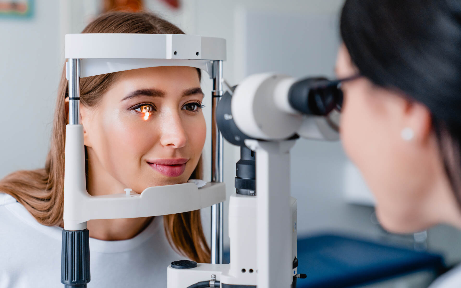 A woman undergoing an eye examination with advanced equipment, highlighting the importance of new eye treatments.