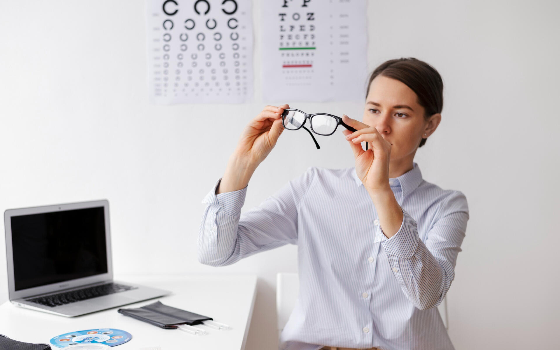 VCD off-season tips for brokers A vision care professional examines eyeglasses in an office, illustrating off-season tips for brokers to stay engaged and proactive.