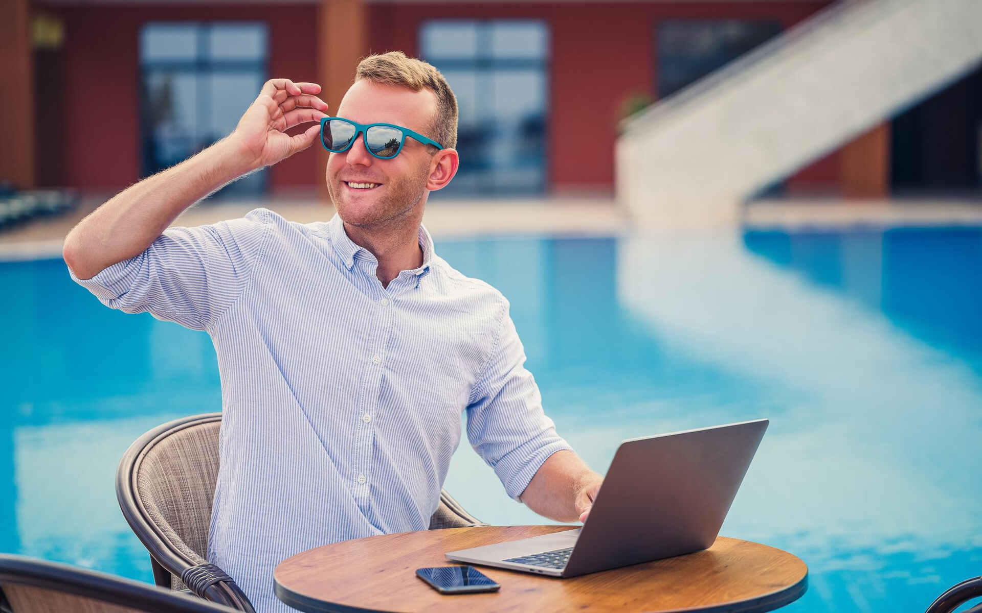 vcd professional vision care A man working on a laptop by the pool, symbolizing flexibility and professional vision care lifestyle.