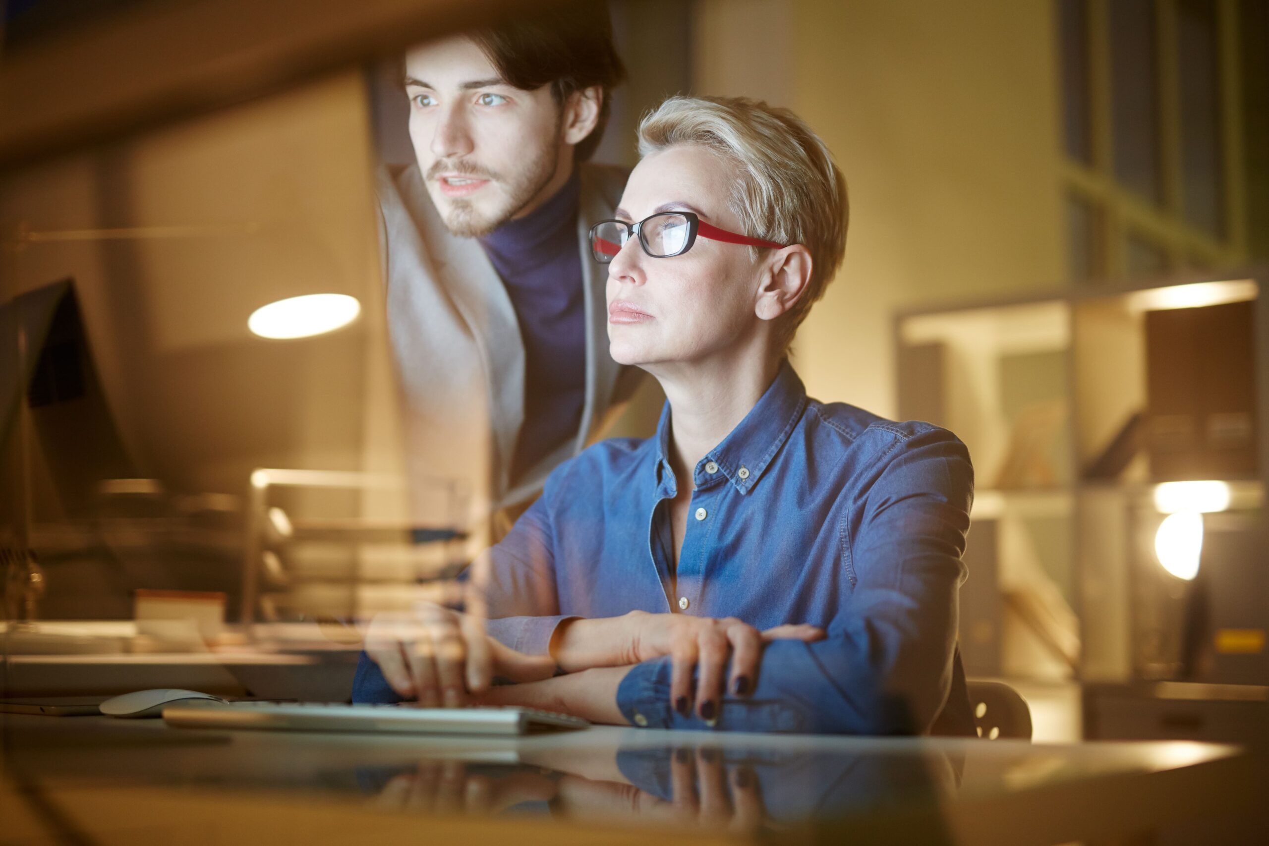 why employers need vision benefits Two professionals reviewing data on a computer screen, representing why employers need vision benefits for a focused and productive workforce.